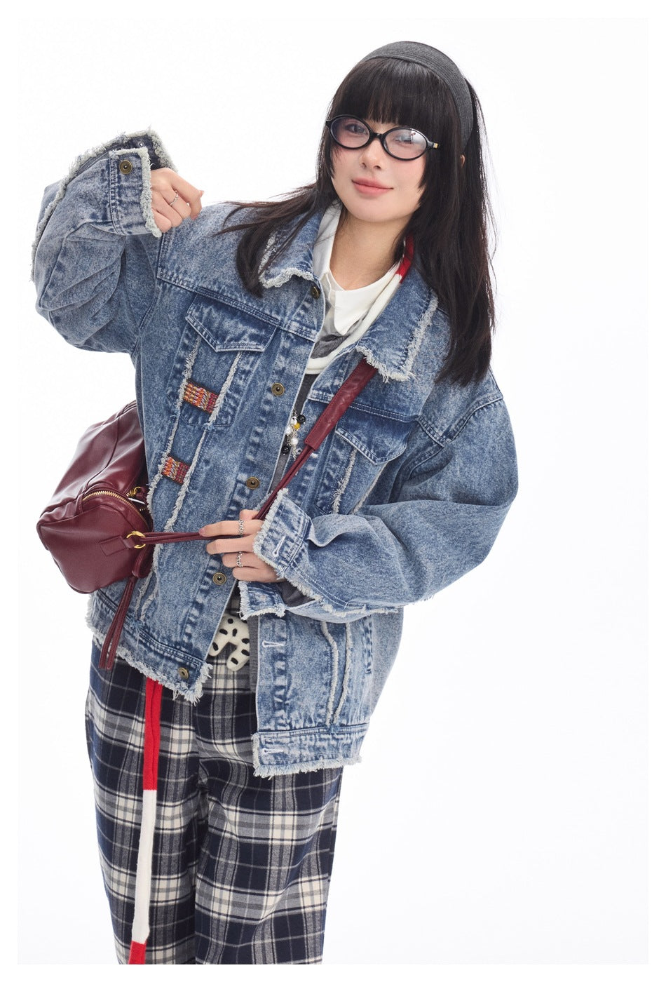 Model in a distressed blue denim jacket with frayed edges, front buttons, and flap chest pockets.