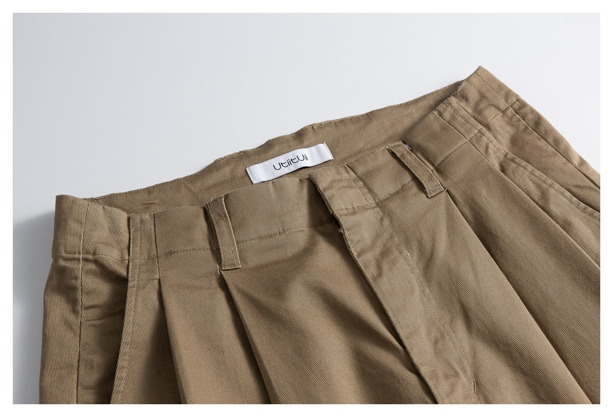 Close-up of the shorts' taupe waistband, belt loops, pleats, and sewn-in label.
