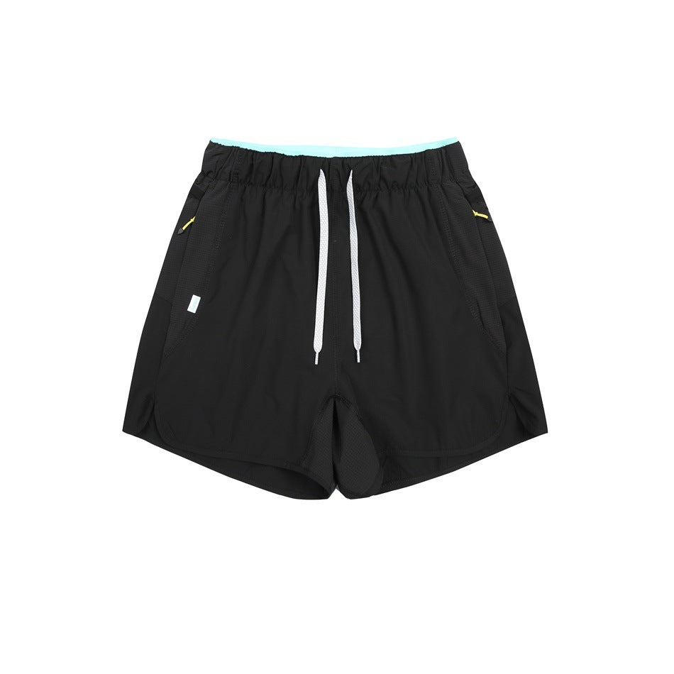 Black drawstring shorts with aqua waistband trim and yellow zipper pulls, flat lay front view