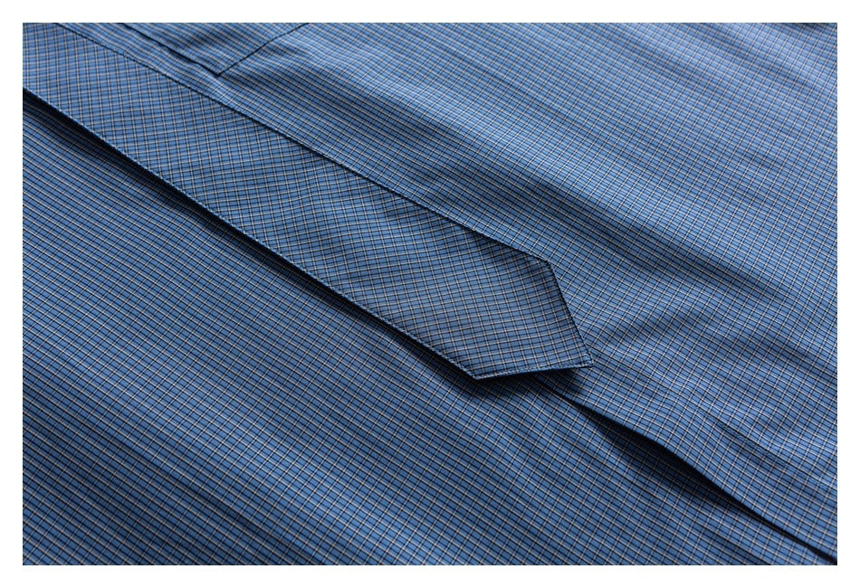 Close-up of a blue checked shirt collar laid against the matching shirt fabric.