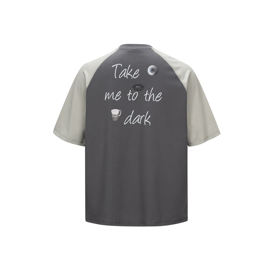Back of dark gray raglan T-shirt with light gray sleeves and large white script print with eye, lips and mug graphics