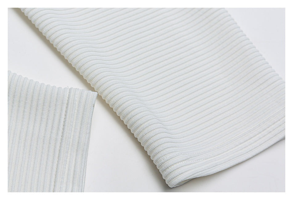 Close-up of white ribbed knit fabric with a curved finished edge and a second ribbed section.