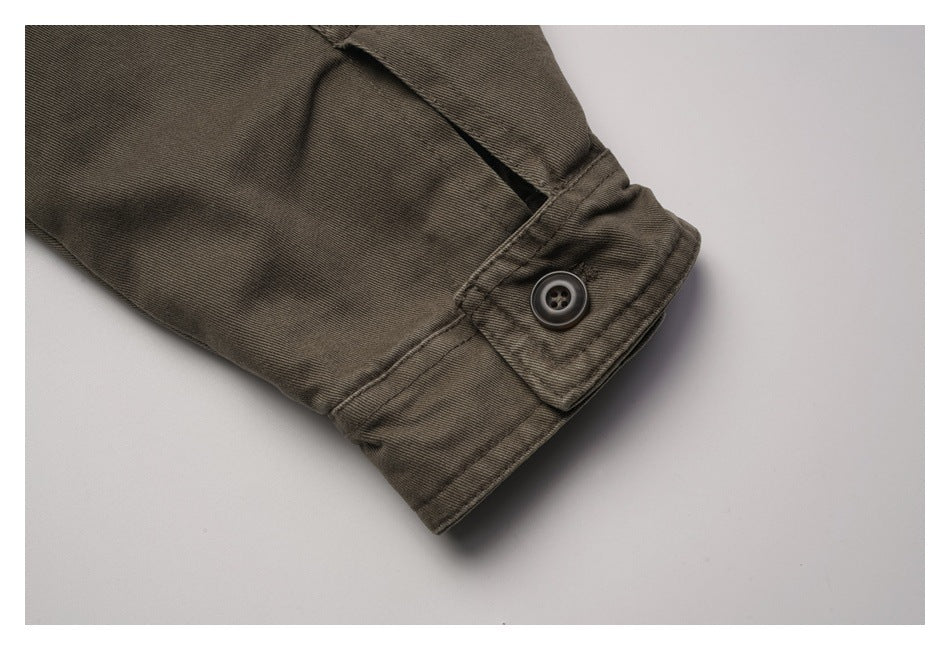Close-up of the olive-brown jacket sleeve cuff with a button closure.