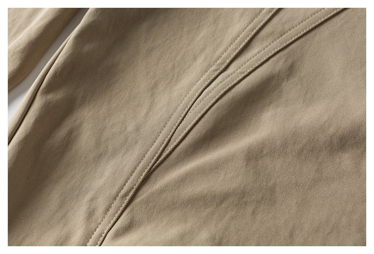 Close-up of khaki shorts fabric and a curved double-stitched seam.