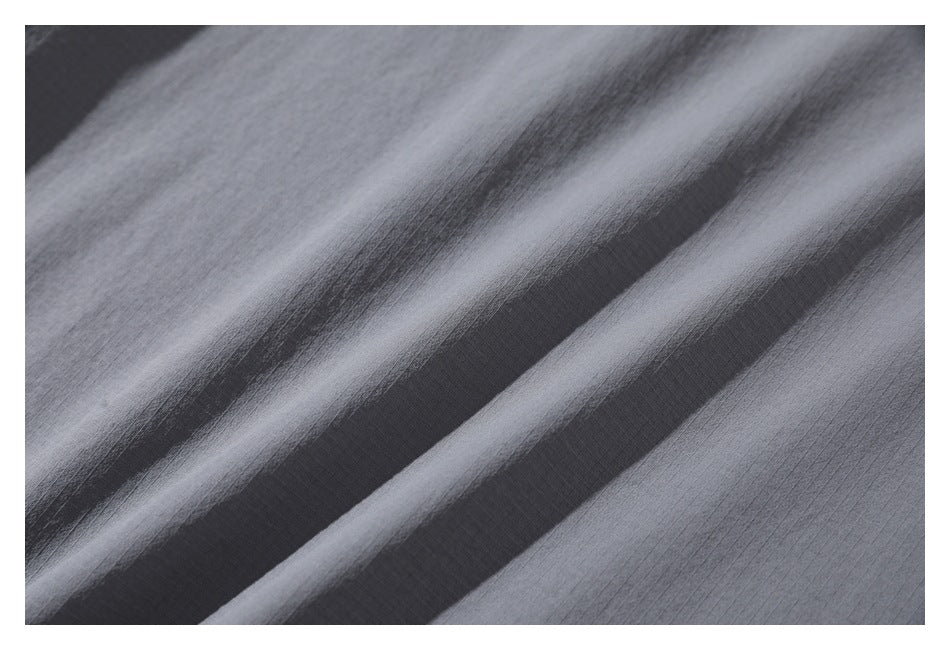 Close-up of the subtle grid texture on gray fabric, shown in soft folds.