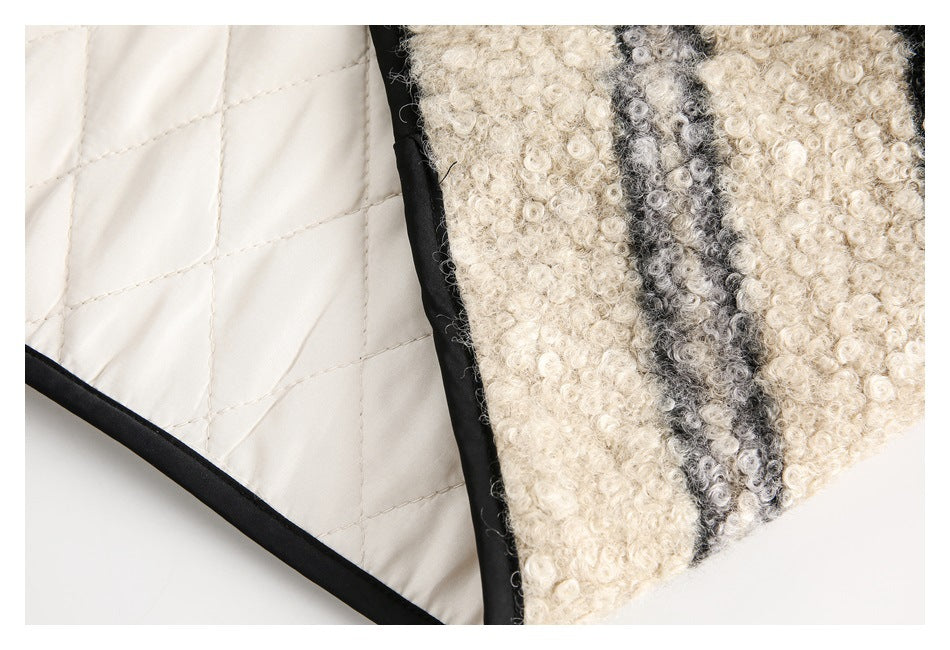 Close-up showing the cream quilted lining beside the cream and gray striped exterior of a jacket.