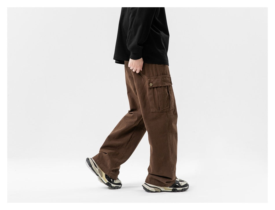 Side view of a model wearing loose brown cargo pants with a buttoned flap thigh pocket.