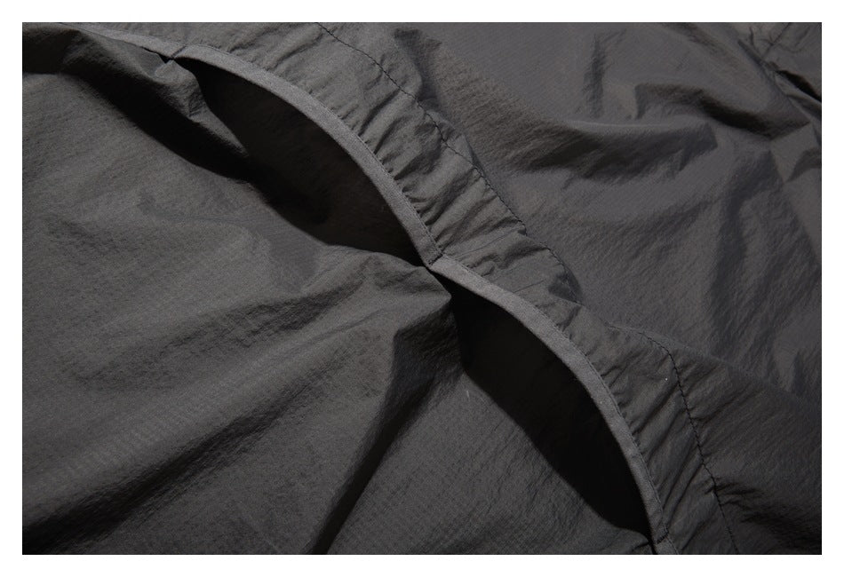 Close-up of dark charcoal fabric showing a curved bound edge and an opening between panels.