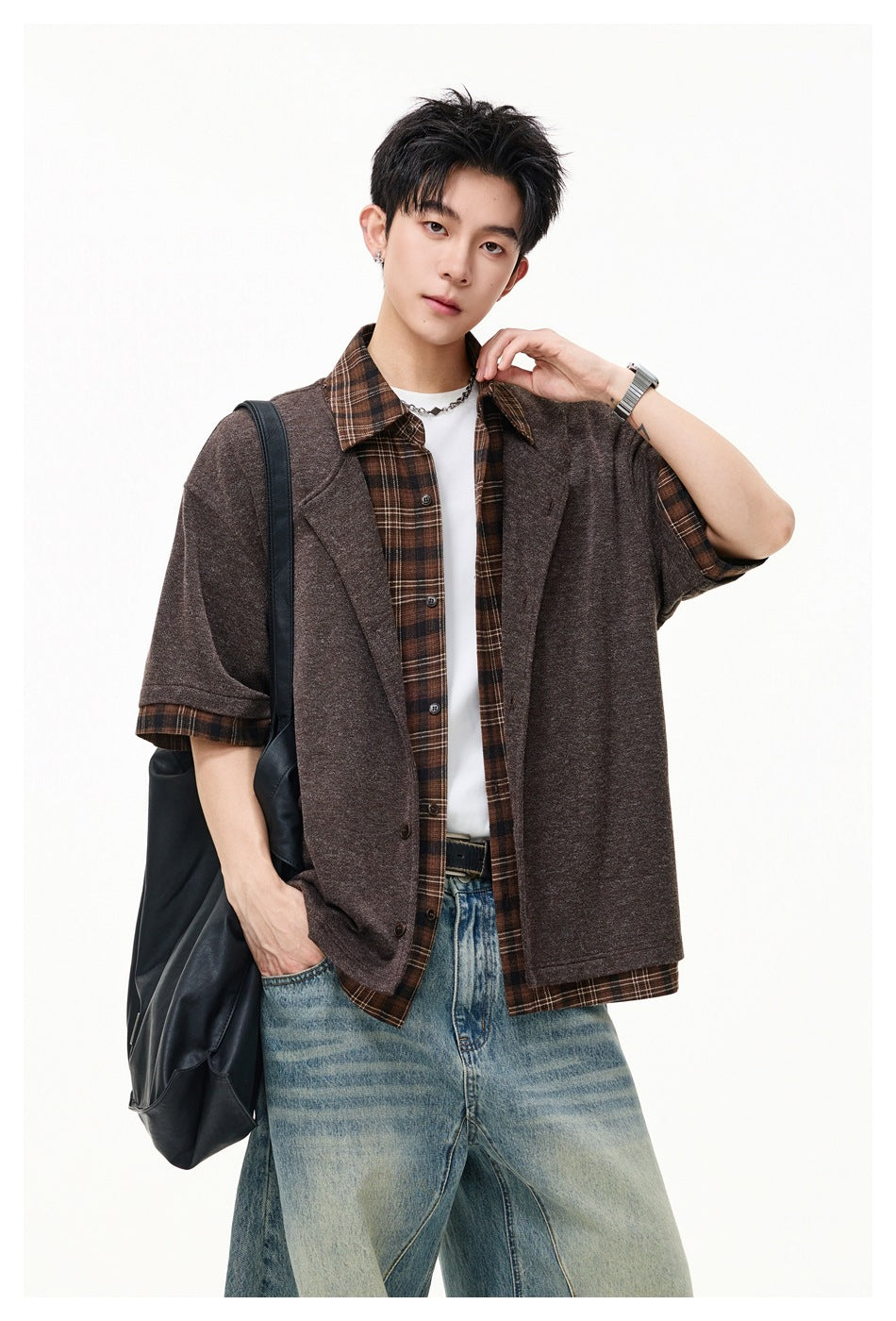 Model wearing an open brown short-sleeve jacket with lapels over a brown plaid shirt.