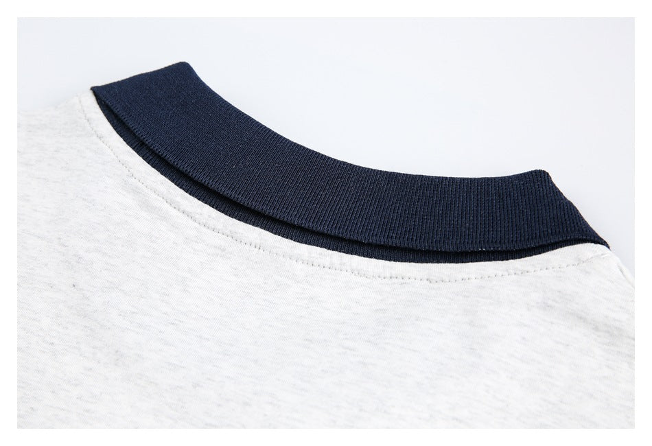 Close-up of a dark navy ribbed collar against light heather gray fabric.