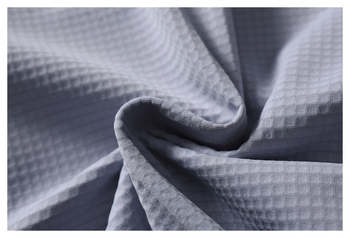 Close-up of folded gray garment fabric showing its fine textured weave and drape.