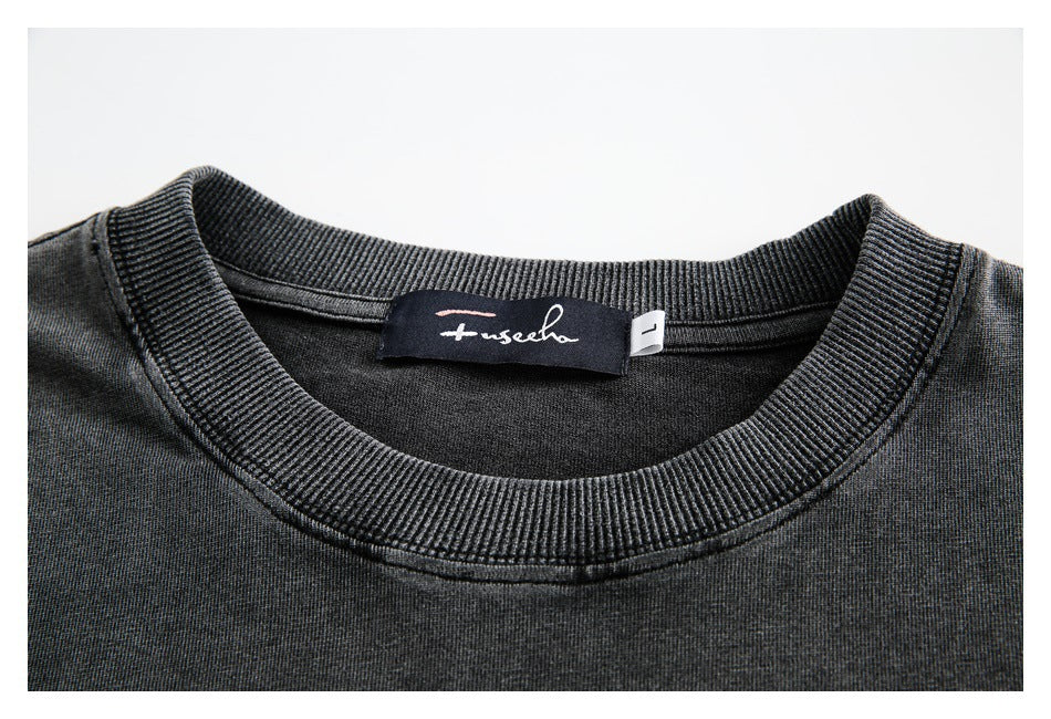 Close-up of a charcoal sweatshirt's ribbed crew neckline and sewn-in neck label.