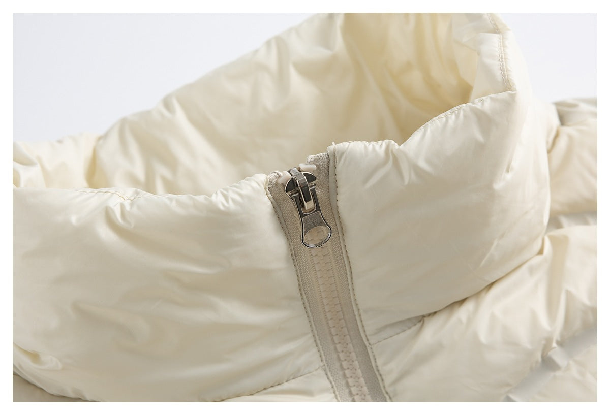 Close-up of the ivory jacket’s zipper pull and tall padded collar.