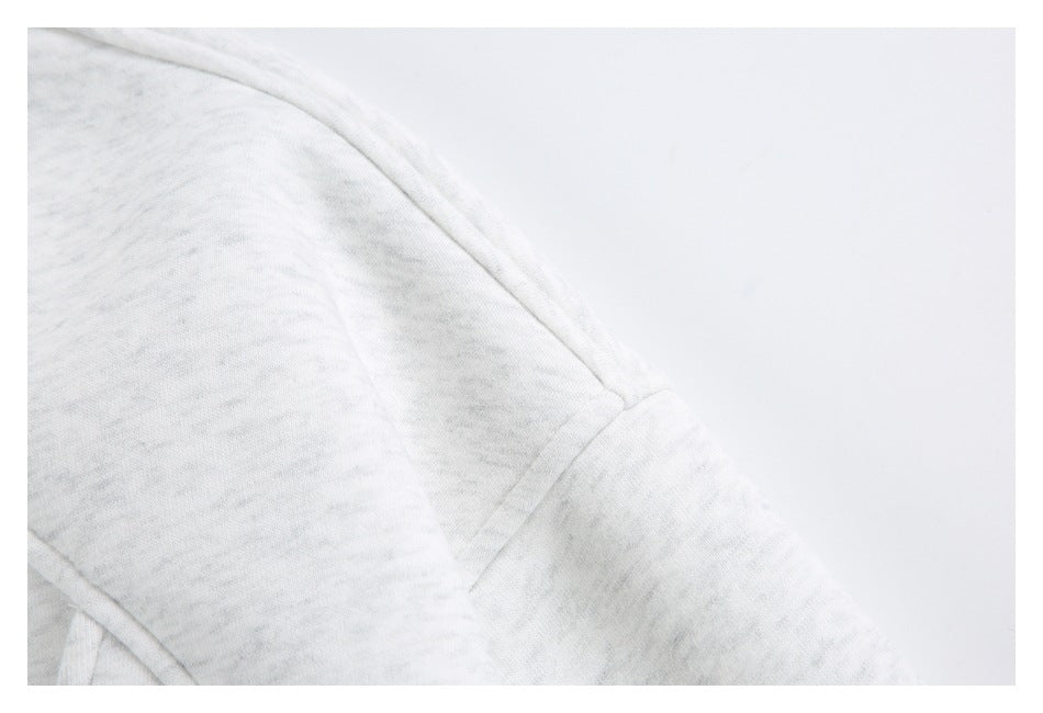 Close-up of the light gray marled jacket's shoulder seam and sleeve.