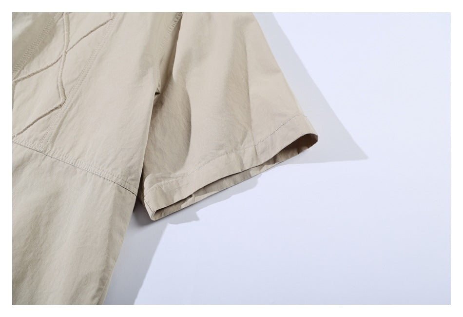 Close-up of a short sleeve and stitched cuff on a light khaki garment.