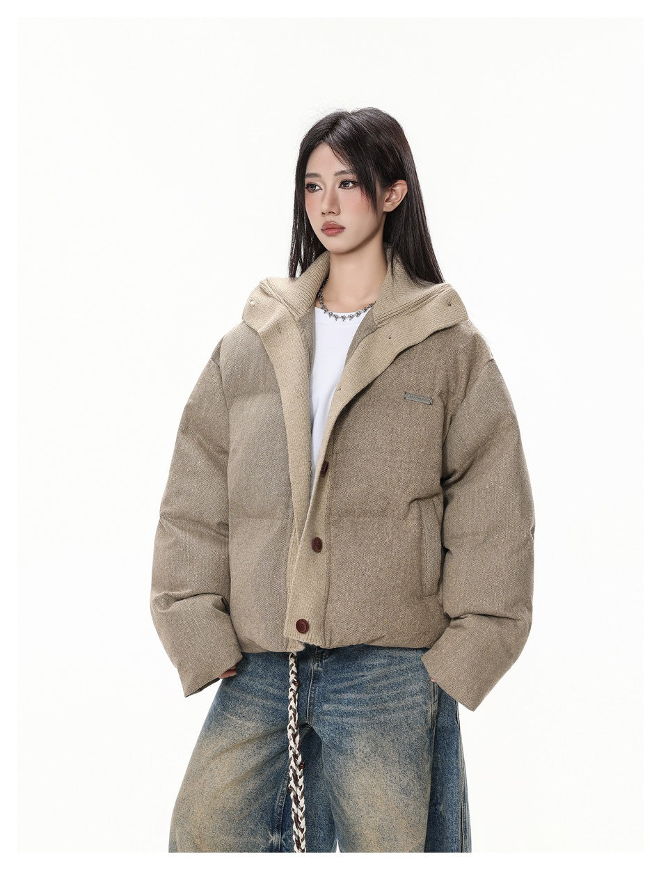 Woman wearing a tan puffer jacket with a beige knit collar over a white top and faded wide-leg jeans, three-quarter view