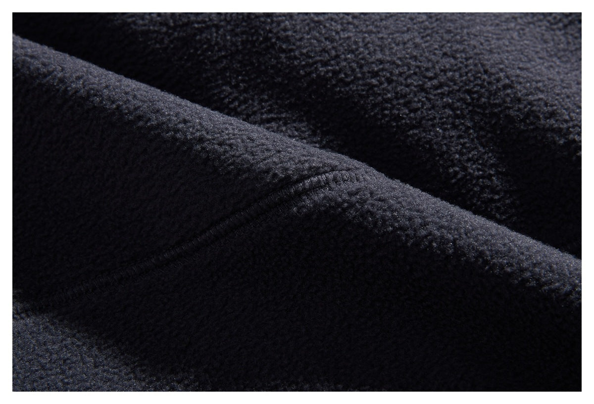 Close-up of a stitched seam on dark navy fleece fabric.