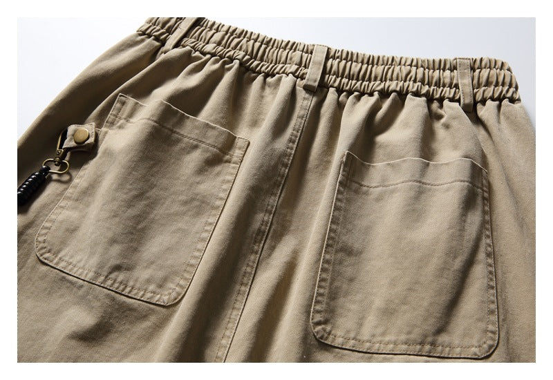 Back view of beige pants with an elastic waistband and two large patch pockets.
