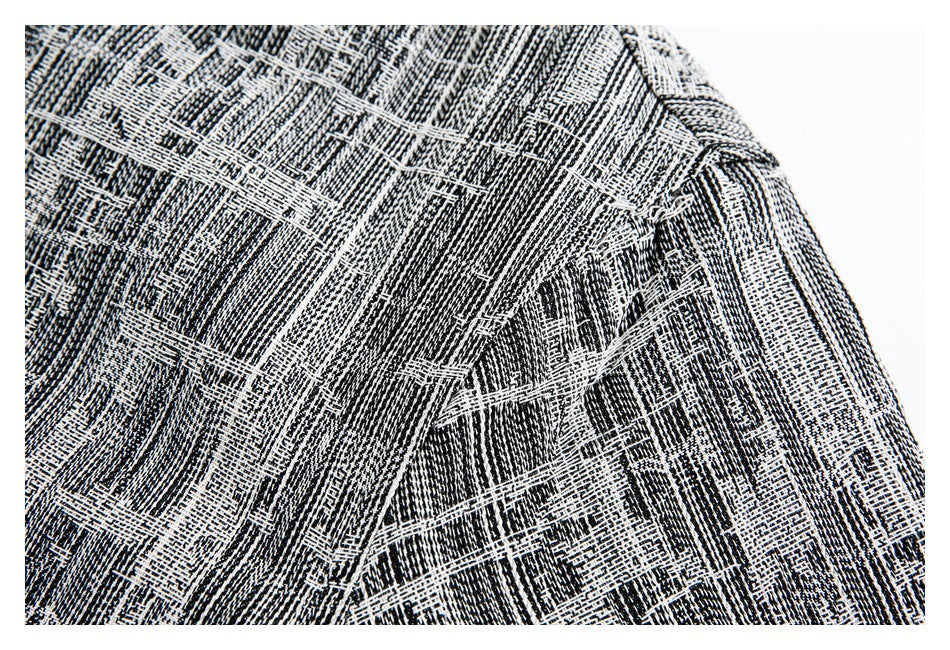 Close-up of black-and-white patterned fabric showing an overlapping seam and stitched panel.