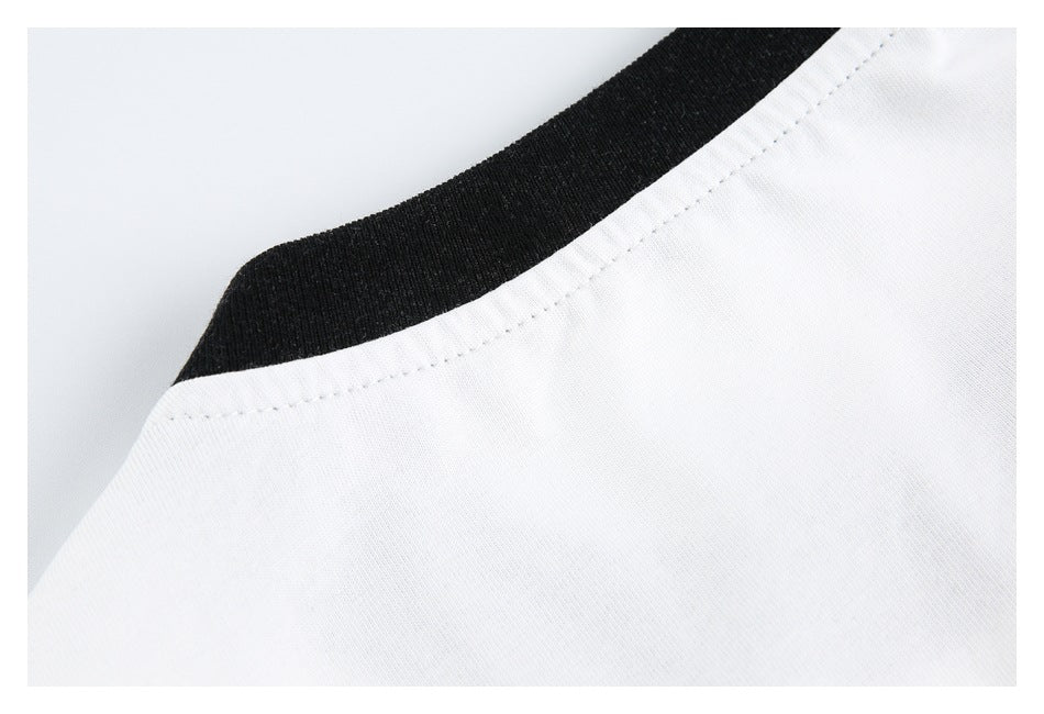 Close-up of a white shirt with black ribbed collar trim and neckline stitching.