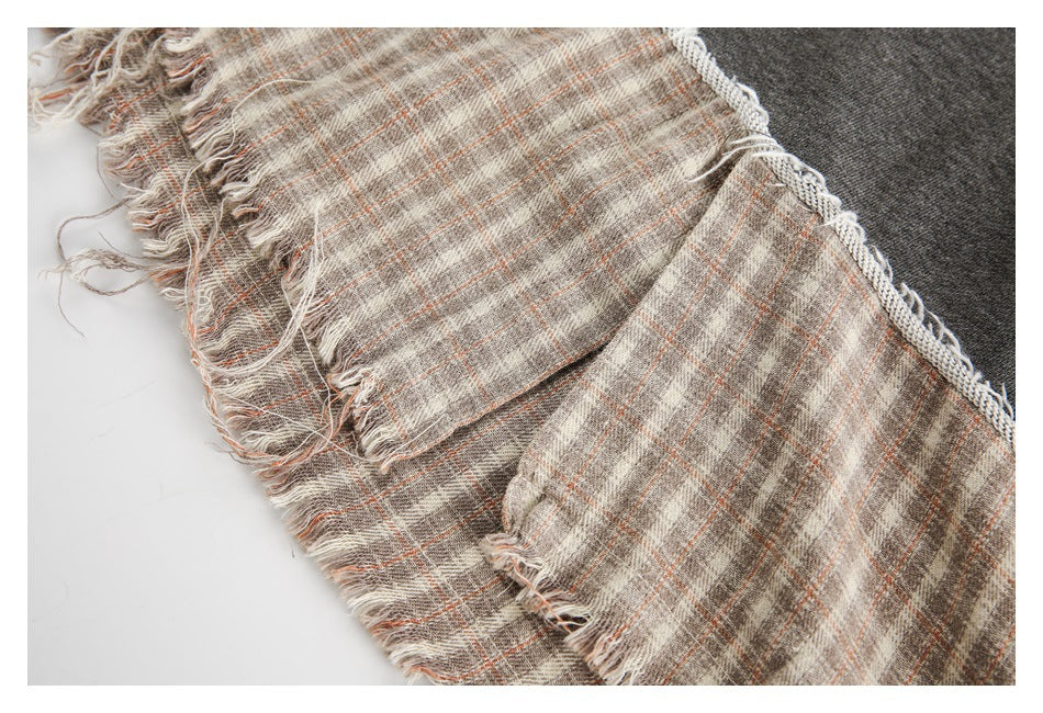 Close-up of the sweatshirt’s beige plaid hem panel with loose, frayed edges.