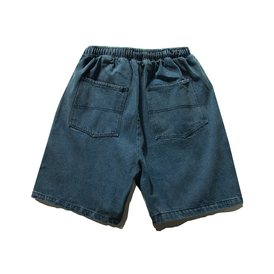 Back view of dark blue denim shorts with an elastic waistband and two large patch pockets.