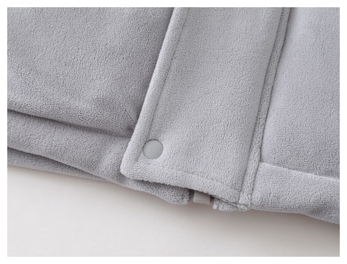 Close-up of the light gray jacket's snap-button front placket and lower hem.