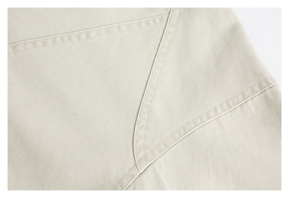 Close-up of cream jacket fabric and curved panel seams.