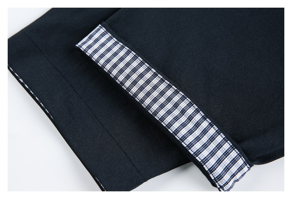 Close-up of a navy jacket edge with a strip of black-and-white checked trim.