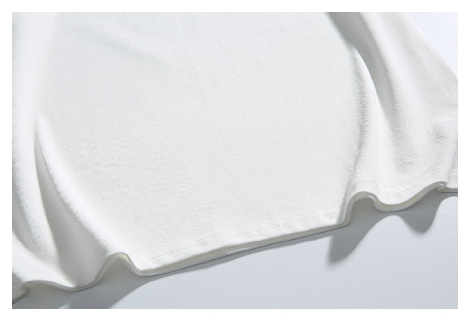 Close-up of the plain white shirt fabric and stitched bottom hem.