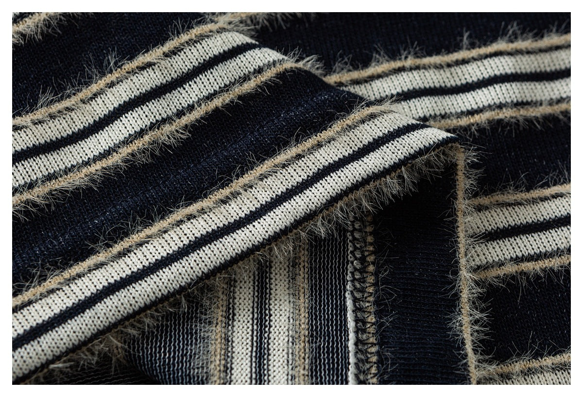 Close-up of striped navy and cream knit fabric showing a seam and the reverse side.