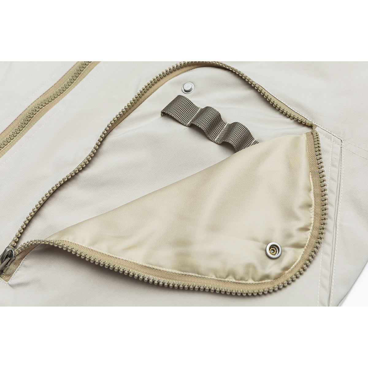 Close-up of the jacket's open zippered pocket, showing its lining and snap fasteners.
