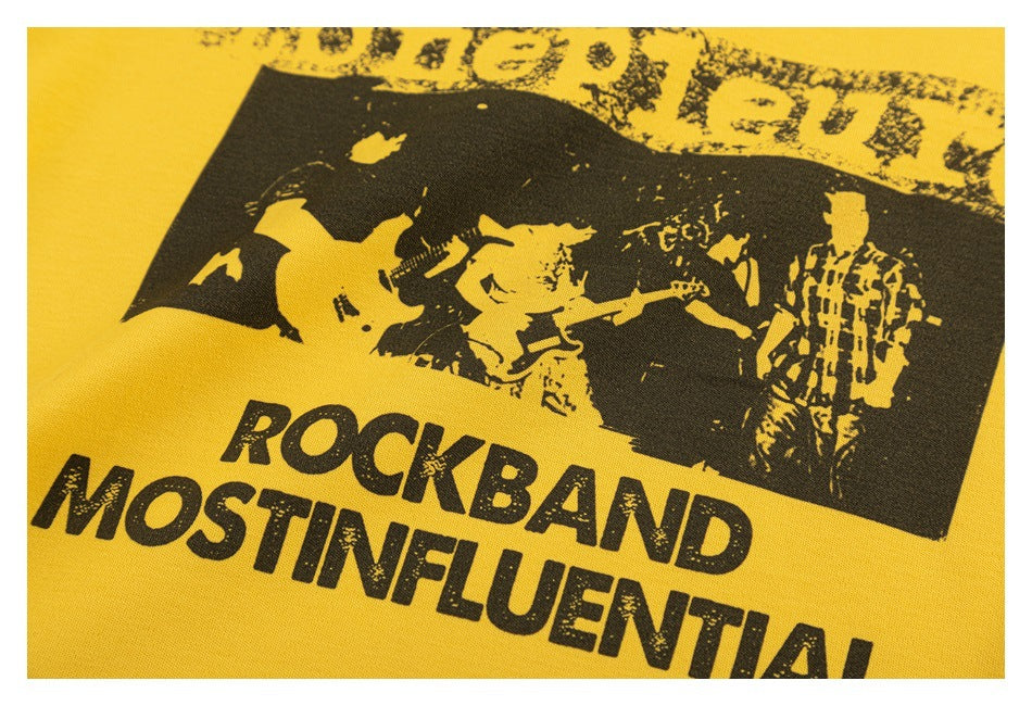 Close-up of the yellow shirt's distressed black graphic showing musicians and bold lettering.
