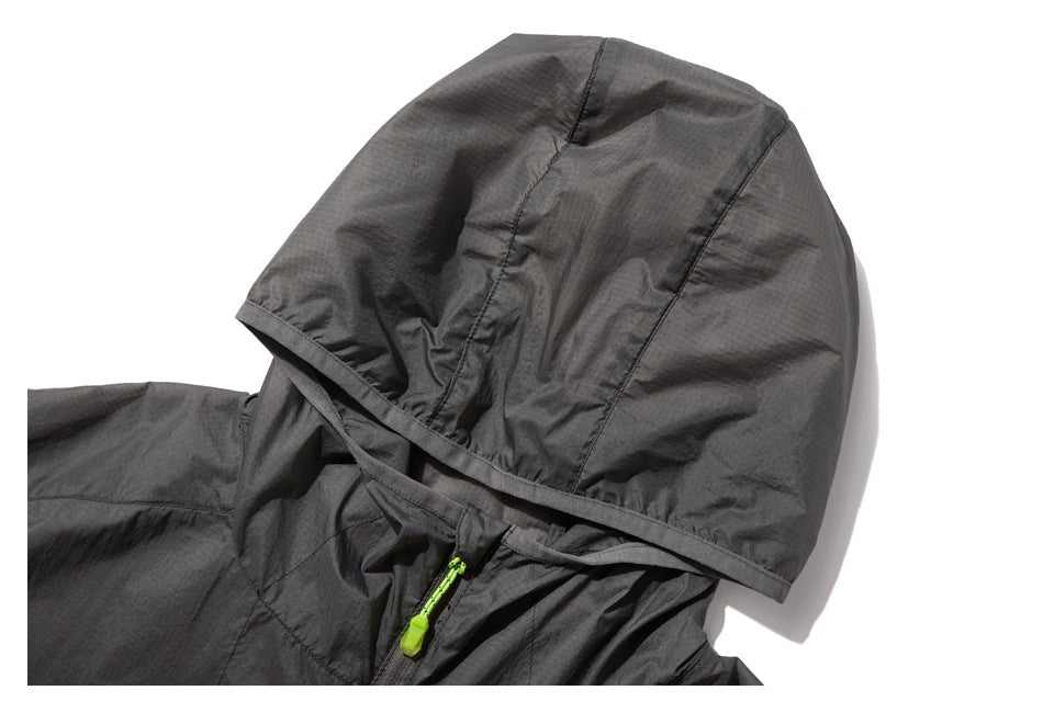 Close-up of the charcoal jacket's hood, showing stitched panels and a bright green zipper pull at the neckline.