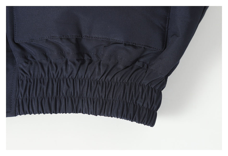 Close-up of the jacket's gathered elastic hem below a flap pocket.