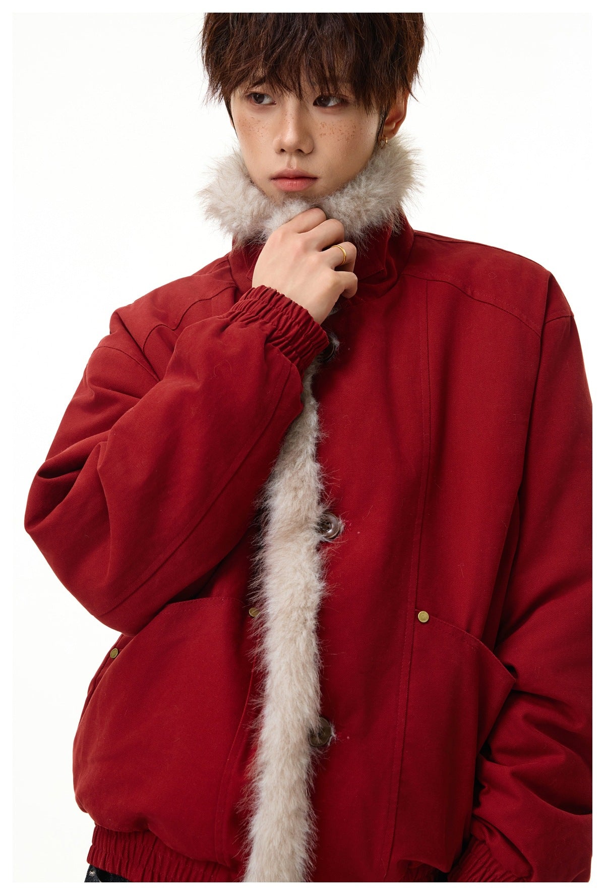Close view of a model wearing a deep red jacket with a plush light beige fur-trimmed collar and front.
