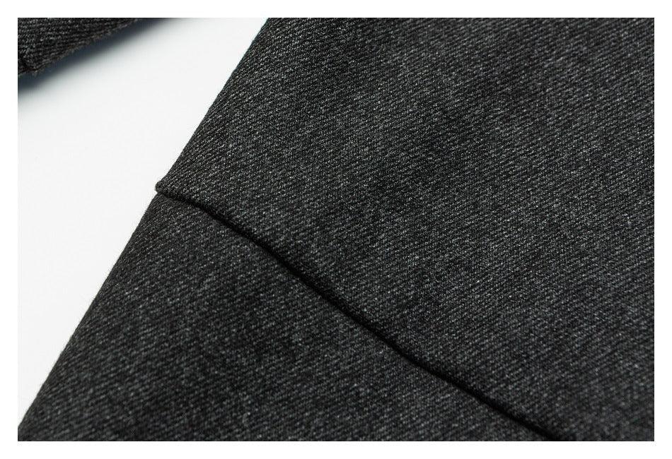 Close-up of a stitched seam on charcoal trousers.
