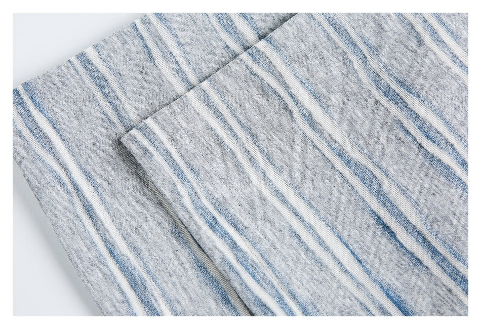 Close-up of striped gray knit fabric and a stitched seam where panels overlap.