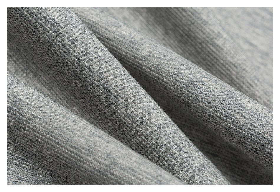 Close-up of gray knit fabric with a fine, textured weave and soft folds.