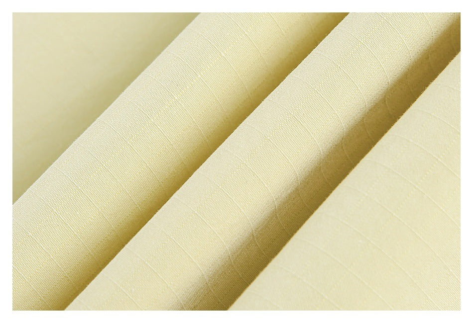 Macro view of the pale yellow fabric's fine woven texture and subtle grid pattern.