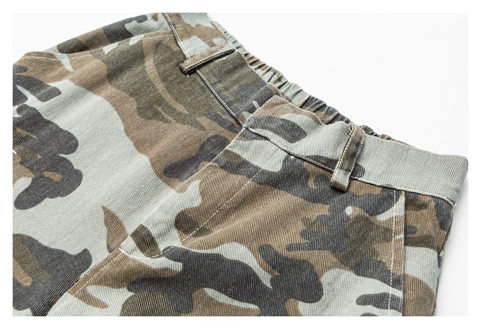 Cropped view of the front waistband and upper panel of camouflage trousers, with belt loops and elastic at the back.
