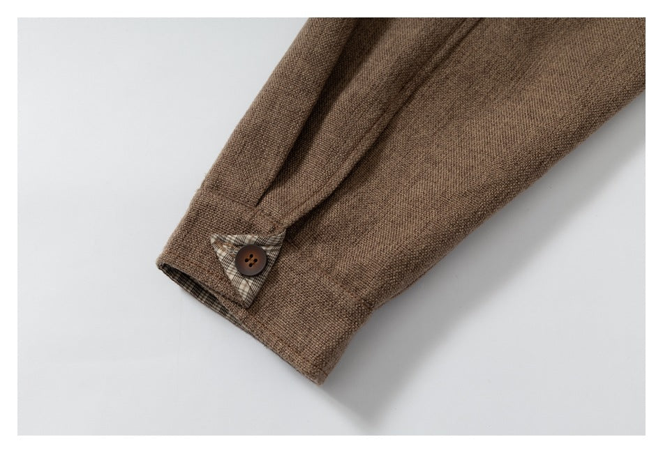 Brown sleeve cuff detail with a brown button and a small plaid lining accent.