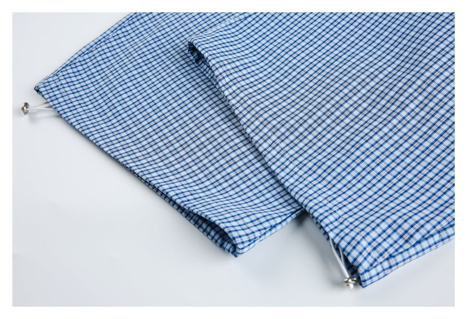 Blue-and-white plaid fabric with a white drawcord and small metal end pieces at the edge.