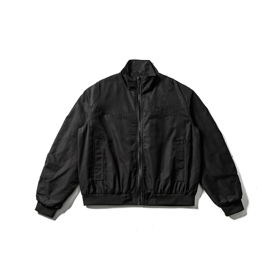 Black bomber-style zip jacket flat lay with stand collar, front pockets, ribbed cuffs and hem