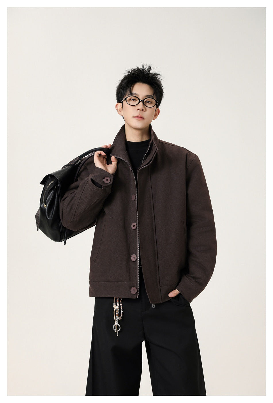 Model wearing a dark brown stand-collar jacket with a buttoned front and zipper.