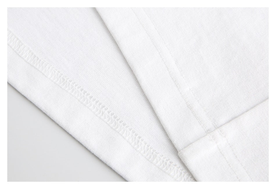 Extreme close-up of white garment fabric and overlocked seam stitching.