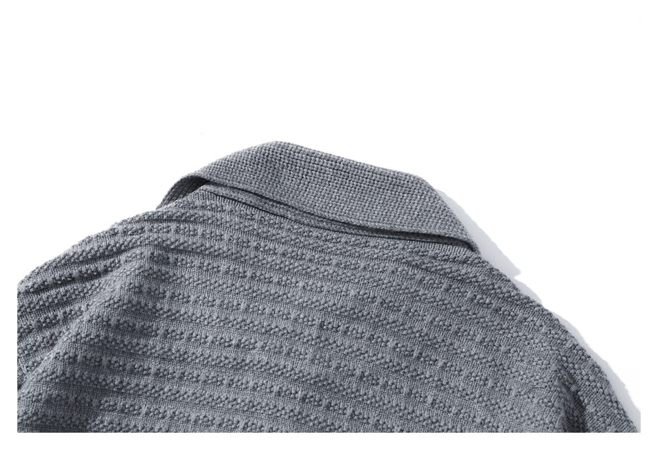 Close-up of the folded rib-knit collar and upper back of a gray textured cardigan.