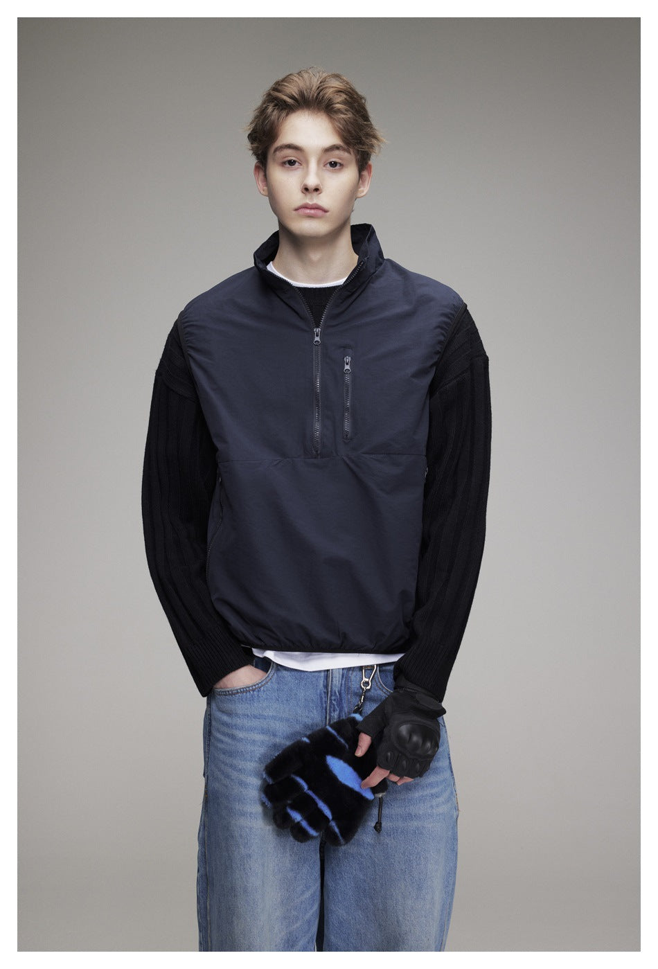 Model wearing a dark navy sleeveless pullover vest with a stand collar, front half-zip, and vertical chest pocket.