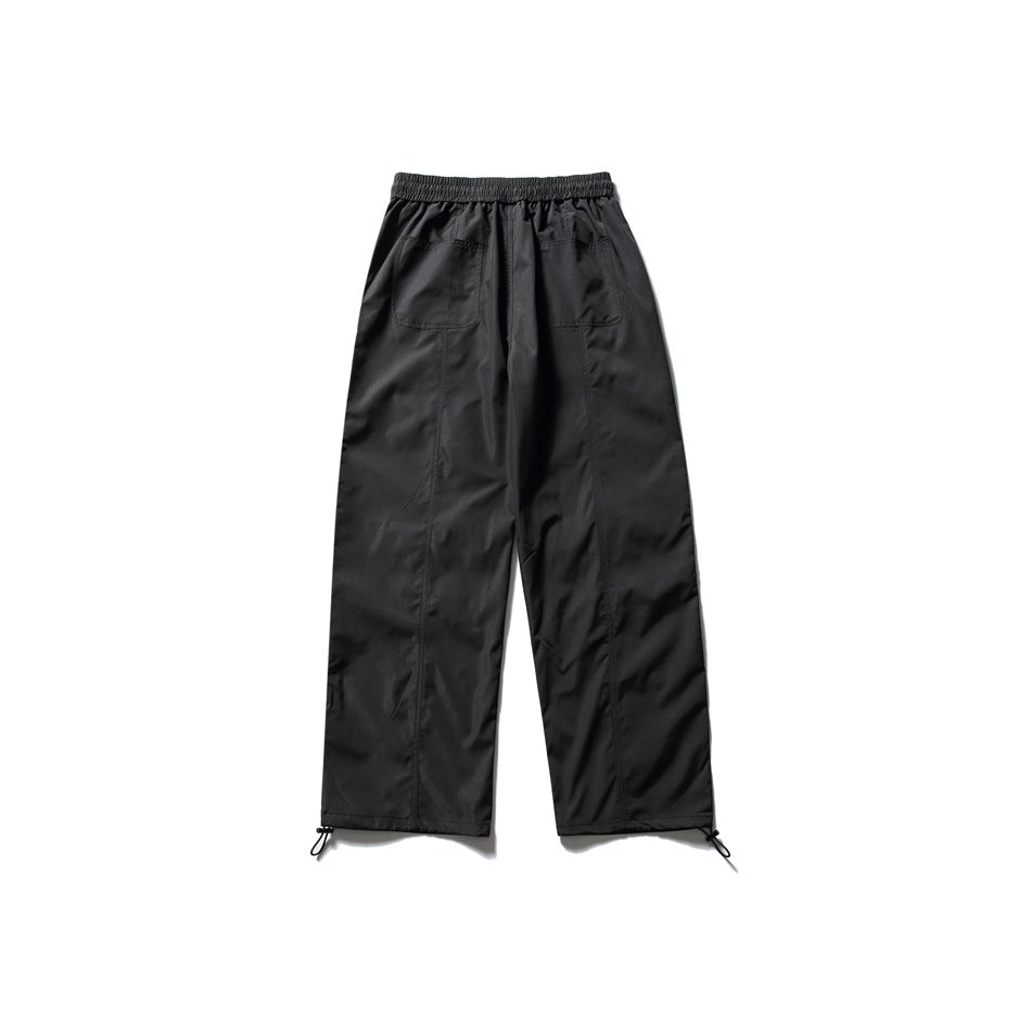 Back view of black wide-leg pants with an elastic waist, two patch pockets, and adjustable ankle cords.
