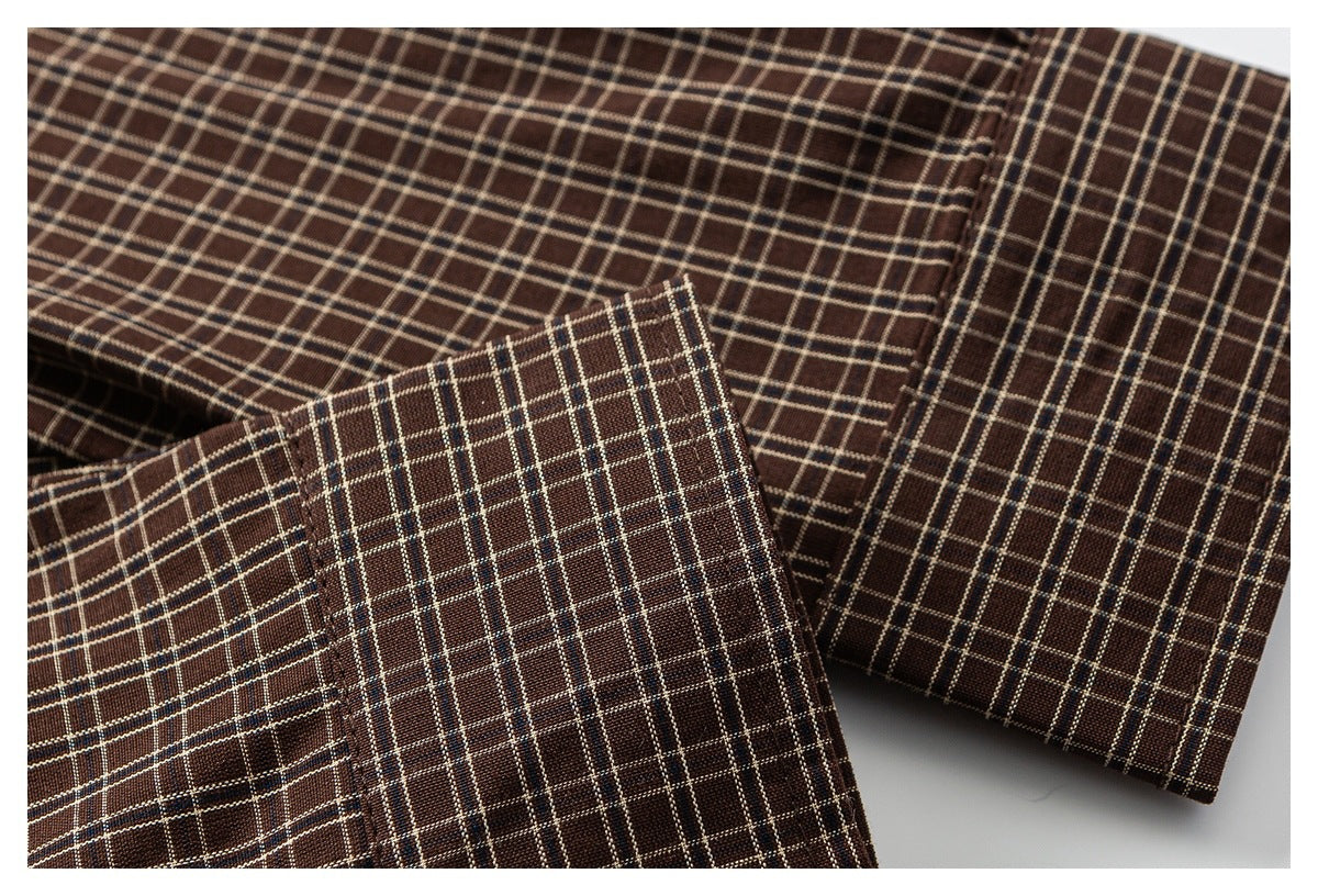 Close-up of the cuff and sleeve of a brown plaid shirt.